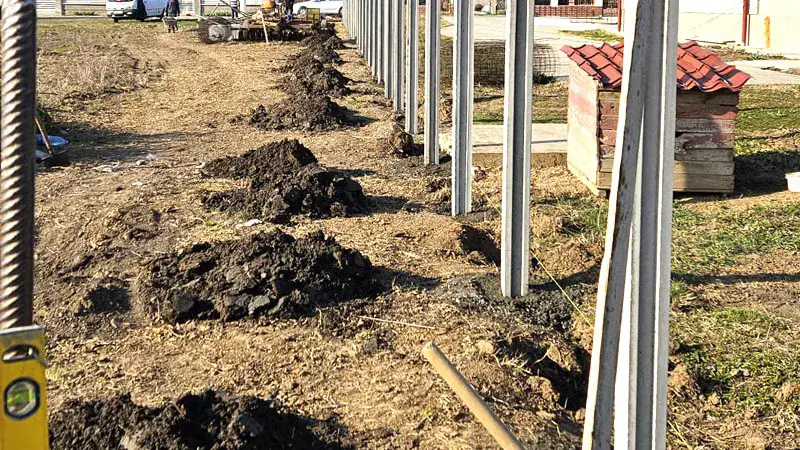 Aushub und Betonpfosten während der Montage eines Zauns