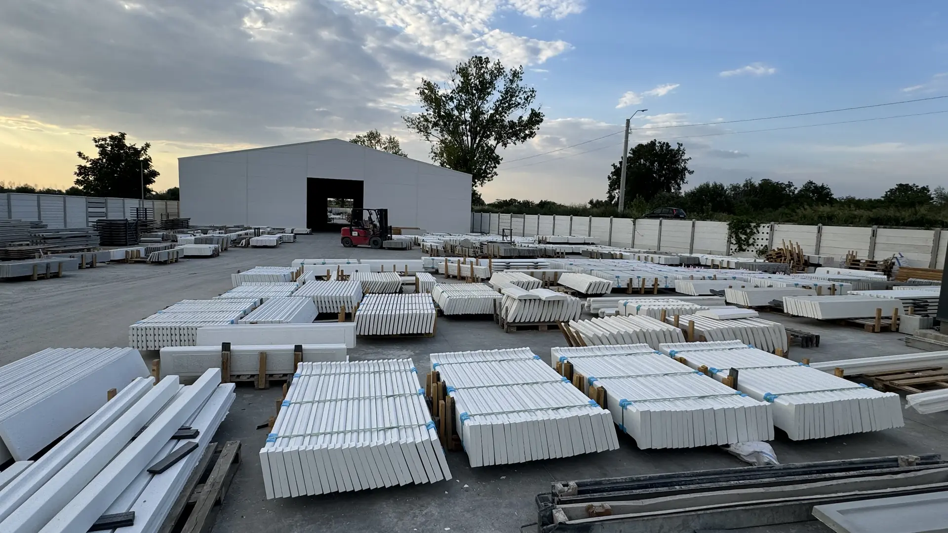 Der Hof des Konkret Line Werks in Măgurele am Abend — fertige Zaunplatten vor der Halle