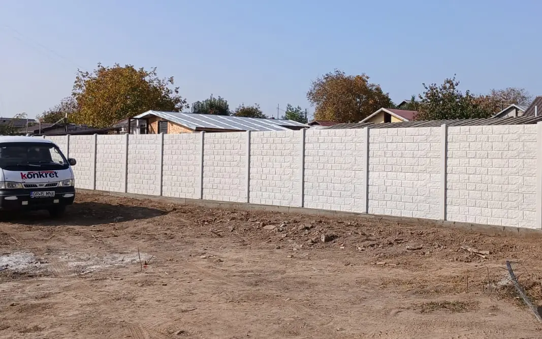 Fahrzeug von Konkret Line neben einem fertigen Betonzaun